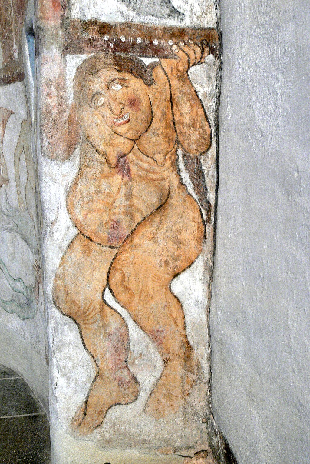 Fresco depicting a naked figure holding a beam, showcasing exaggerated facial features and body proportions.